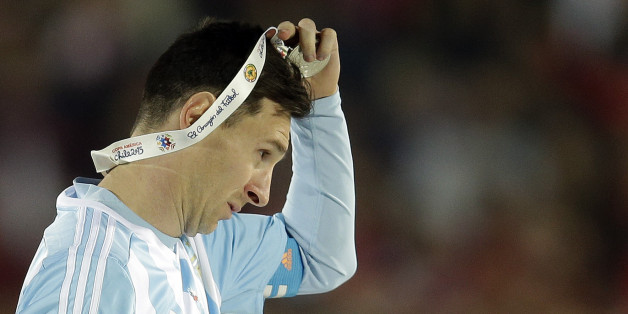 Argentina's Lionel Messi takes off the Copa America silver medal after the final game with Chile at the National Stadium in Santiago, Chile, Saturday, July 4, 2015. Chile's goalkeeper Claudio Bravo made a save and striker Alexis Sanchez converted the winning penalty as host Chile defeated Argentina 4-1 in a shootout after a 0-0 draw in the Copa America final.(AP Photo/Natacha Pisarenko)