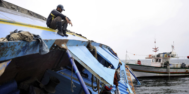 A Tunisian fisherman sits on a capsized ship that originated from Libya and which according to the United Nations refugee agency was transporting an estimated 850 refugees, as it lies on a sandbar 35 kilometers (22 miles) north of the Tunisian islands of Kerkennah, Saturday, June 4, 2011. The Geneva-based agency said Friday that at least 578 of the estimated 850 people on board, mostly from West Africa, Pakistan and Bangladesh, survived the Wednesday sinking, making it one of the worst and deadl