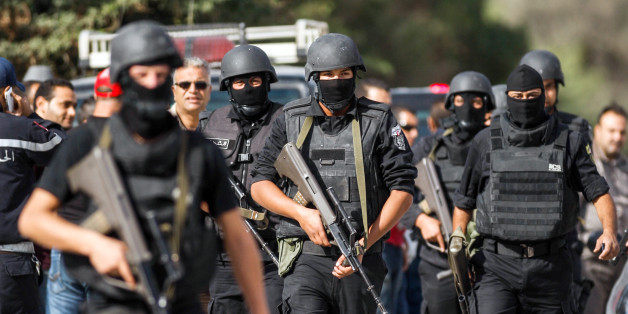 Members of the Tunisian National Guard take positions as they secure the scene of a shooting in the Oued Ellil suburb of Tunis, Tunisia, Thursday, Oct. 23, 2014. A Tunisia official says a security officer has been killed in a shootout that began when a suspect's home was surrounded near the capital. Interior Ministry spokesman Mohammed Ali Aroui says the exchange of fire Thursday came after a pair of counterterrorism operations in the south that left one bystander dead. (AP Photo/Aimen Zine)