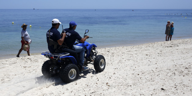 Tunisian police officers patrol on a beach in front of the Imperial Marhaba Hotel in Sousse, Tunisia, Sunday, June 28, 2015. Tunisia's top security official says 1,000 extra police are being deployed at tourist sites and beaches in the North African nation. (AP Photo/Darko Vojinovic)