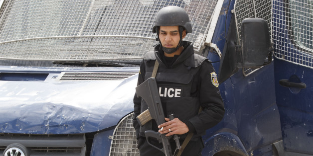 An armed Tunisian police officer, stands guard at the morgue of the Charles Nicolle hospital in Tunis, Tunisia, Friday, March 20, 2015. The two extremist gunmen who killed 21 people at a museum in Tunis trained in neighboring Libya before caring out the deadly attack, a top Tunisian security official said. (AP Photo/Michel Euler)