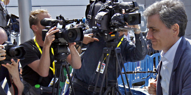 Greek Finance Minister Euclid Tsakalotos, right, arrives for a meeting of eurozone finance ministers at the EU Lex building in Brussels on Saturday, July 11, 2015. Greece's negotiators head to Brussels on Saturday armed with their reform proposals and parliamentary backing to seek a third bailout, but with the shadow of severe dissent from governing lawmakers hanging over them. (AP Photo/Francois Walschaerts)