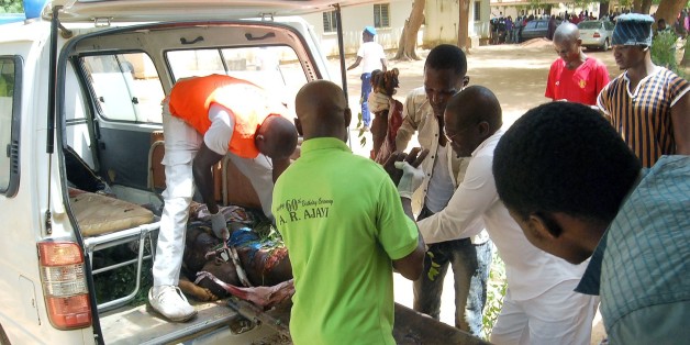 **GRAPHIC CONTENT**
Health officials carry the body of a victim of a suicide bomb attack out of an ambulance in Potiskum, in northeast Nigeria's Yobe State, on June 15, 2015. Ten people were killed in twin suicide bombings in Potiskum, northeast Nigeria, a police source and a civilian vigilante assisting the military against Boko Haram told AFP on June 15. Eight vigilantes were killed in the first blast in the Igwanda area of the city, while two died in the second outside a tavern and brothel in the Dorawa area. AFP PHOTO / AMINU ABUBAKAR (Photo credit should read AMINU ABUBAKAR/AFP/Getty Images)