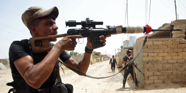 Iraqi Shiite fighters from the Popular Mobilisation force keep position during a battle against jihadists from the Islamic State group to retake the strategic town Baiji, north of Tikrit, on June 8, 2015. Baghdad regained control of Baiji -- located on the road to IS hub Mosul and near the country's largest oil refinery -- last year, but subsequently lost it again. AFP PHOTO / AHMAD AL-RUBAYE (Photo credit should read AHMAD AL-RUBAYE/AFP/Getty Images)