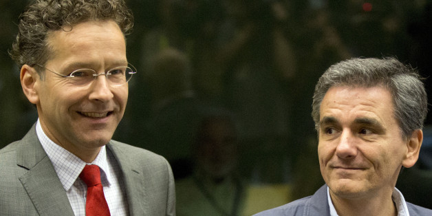 Dutch Finance Minister and chair of the eurogroup Jeroen Dijsselbloem, left, speaks with Greek Finance Minister Euclid Tsakalotos during a round table meeting of eurozone finance ministers at the EU LEX building in Brussels on Tuesday, July 7, 2015. Greek Prime Minister Alexis Tsipras was heading Tuesday to Brussels for an emergency meeting of eurozone leaders, where he will try to use a resounding referendum victory to eke out concessions from European creditors over a bailout for the crisis-ri