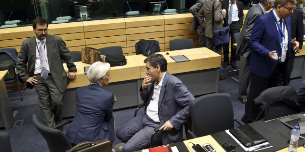 Greek Finance Minister Euclid Tsakalotos. center right, speaks with Managing Director of the International Monetary Fund Christine Lagarde, center left, during a round table meeting of eurogroup finance ministers at the EU Lex building in Brussels on Sunday, July 12, 2015. Greece has another chance Sunday to convince skeptical European creditors that it can be trusted to enact wide-ranging economic reforms which would safeguard its future in the common euro currency. (AP Photo/Michel Euler)