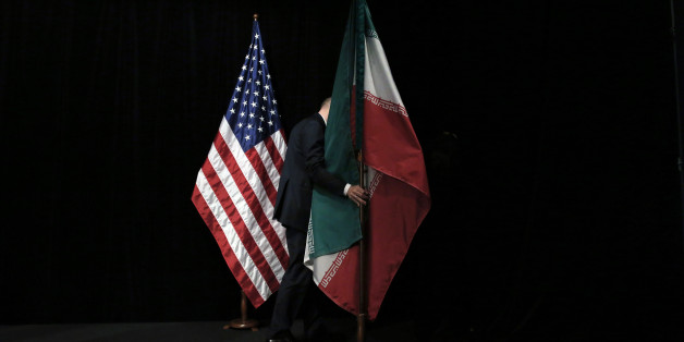 A staff member removes the Iranian flag from the stage after a group picture with foreign ministers and representatives of Unites States, Iran, China, Russia, Britain, Germany, France and the European Union during the Iran nuclear talks at the Vienna International Center in Vienna, Austria Tuesday July 14, 2015. After 18 days of intense and often fractious negotiation, world powers and Iran struck a landmark deal Tuesday to curb Iran's nuclear program in exchange for billions of dollars in reli