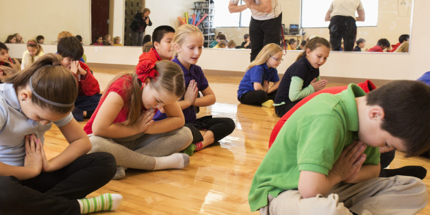 Children meditating in gym class