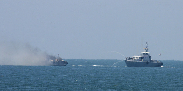 Egyptian navy vessel hoses down another which caught on fire at Mediterranean Sea Thursday, July 16, 2015. An Egyptian navy vessel caught fire off the coast of Sinai on Thursday after an exchange of gunshots with militants from the shore, the military said. (AP Photo/Eyad Baba)