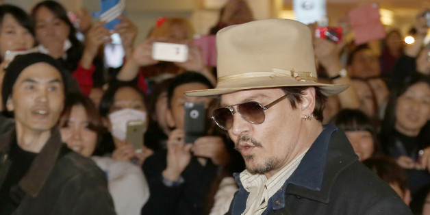 U.S. actor Johnny Depp waves to his fans upon arriving at Haneda international airport in Tokyo Monday, Jan. 26, 2015 for his latest film "Mortdecai" promotion. (AP Photo/Shizuo Kambayashi)