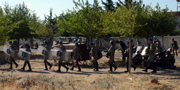 Turkish soldiers walk to their position on the Turkish side of the border in Suruc, Turkey, Friday, June 26, 2015, near the Syrian town of Ayn al-Arab or Kobani. Kurdish fighters have besieged Islamic State members who entered Kobani, activists said Friday adding that two days of fighting have left more than 100 civilians dead. (AP Photo)