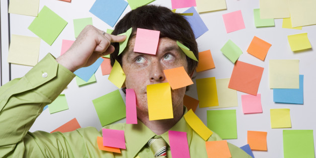Male office worker covered with sticky notes