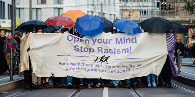 Asylbefürworter ziehen am 27.07.2015 in Dresden (Sachsen) mit einem Banner "Open your mind - stop racism" durch die Innenstadt von Dresden. Die Veranstaltung führt den Demonstrationszug zu einem Flüchtlingslager in Dresden-Friedrichstadt mit rund 800 Bewohnern.
