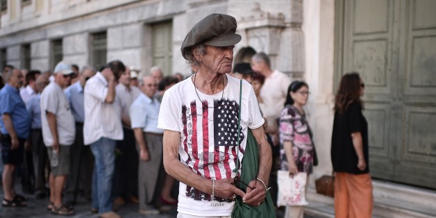People wait outside of a bank in central Athens, prior to its opening on July 20, 2015. Greek banks reopened Monday after a three-week shutdown imposed by the government to avert a crash in the banking system over the country's debt crisis. Capital controls in force since June 29 remain in place, although a daily cash withdrawal limit of 60 euros ($65.03) has now been relaxed. AFP PHOTO/ LOUISA GOULIAMAKI (Photo credit should read LOUISA GOULIAMAKI/AFP/Getty Images)