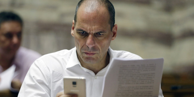 Parliament member Yanis Varoufakis checks his cell phone before a meeting with lawmakers of Syriza party at the Greek Parliament in Athens, Friday, July 10, 2015. Greece's Prime Minister Alexis Tsipras will seek backing for a harsh new austerity package from his party Friday to keep his country in the euro â less than a week after urging Greeks to reject milder cuts in a referendum. (AP Photo/Thanassis Stavrakis)