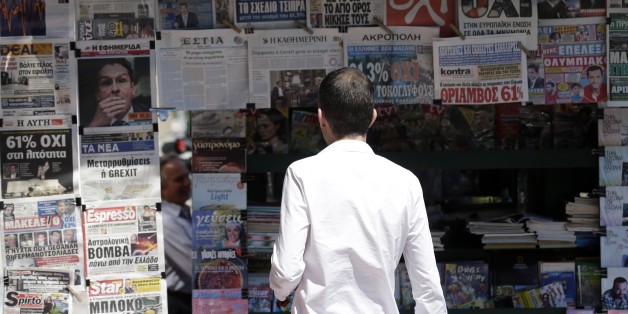 A man reads the front pages of the Greek newspapers in Athens, Monday, July 6, 2015. Greek Finance Minister Yanis Varoufakis resigned Monday, saying he was told shortly after Greece's decisive referendum result that some other eurozone finance ministers and the country's other creditors would appreciate his not attending the ministers' meetings. (AP Photo/Petr David Josek)