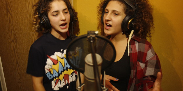 TO GO WITH AFP STORY LIFESTYLE-ISRAEL-PALESTINIAN-ARAB-ENTERTAINMENT-MUSICArab Israeli youths Amani Tatour (R) and Mai Dmar(L) sing the rap duo 'Damar' (Arabic for destruction) in a studio in the city of Nazareth, northern Israel, on October 27, 2011. Mai and Amane, Arab Israeli teenagers living in Nazareth, are happy to leave talk about boys and make-up to their peers. They have a political message and they're telling it through rap music. AFP PHOTO/AHMAD GHARABLI (Photo credit should read AH