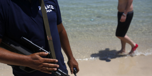 A Tunisian police officer guards the beach in front of the Imperial Marhaba Hotel in Sousse, Tunisia, Sunday, June 28, 2015. Tunisia's top security official says 1,000 extra police are being deployed at tourist sites and beaches in the North African nation. (AP Photo/Darko Vojinovic)