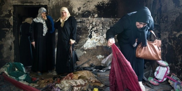 Des palestiniennes évaluent les dégâts dans la maison du bébé palestinien mort dans un incendie imputé à d