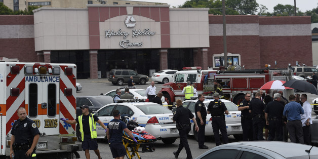 Dozens of law enforcement and emergency responders work in the parking lot after a suspect wielding a hatchet and gun inside a Nashville-area movie theater died after exchanging gunshots with SWAT team members that stormed the theater, police said, Wednesday, Aug. 5, 2015. The suspect, who was not identified, was armed with a gun and hatchet at the Carmike Hickory 8 theater in Antioch, said Don Aaron, a spoke, man for Metro Nashville police. (AP Photo/Mark Zaleski)