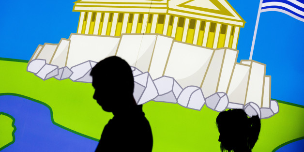 A couple walk in front of a picture displaying the Parthenon, an iconic ancient temple, and the Greek flag in central Athens, Thursday, June 25, 2015. The ECB approved a request from Athens to increase the amount of emergency liquidity Greek lenders can tap from the country's central bank. Worried Greeks have been withdrawing their money from their country's banks, fearing the imposition of restrictions on banking transactions. An estimated more than 4 billion euros ($4.5 billion) left Greek banks last week. (AP Photo/Daniel Ochoa de Olza)