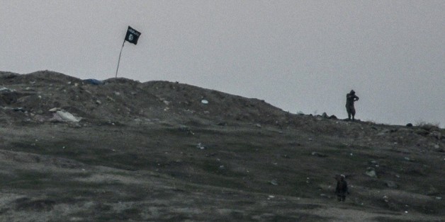 Des militants de l'Etat islamique plantent leur drapeau près de la frontière de la Turquie avec l'Irak, le 23 octobre 2014