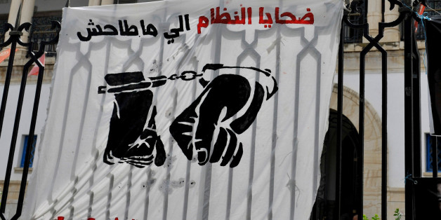FILE - This photo dated May 23, 2014, shows banners hanging on the fence of the Tunis courthouse in Tunisia, in support of a blogger. The arrest for drug possession of Aziz Amami, a prominent blogger from the 2011 revolution that overthrew Tunisiaâs police state, prompted protests and a renewed effort to amend draconian drug laws that many say are used by police to abuse their enemies. On Sunday, Tunisians are set to vote in parliamentary elections that will nearly complete the democratic t