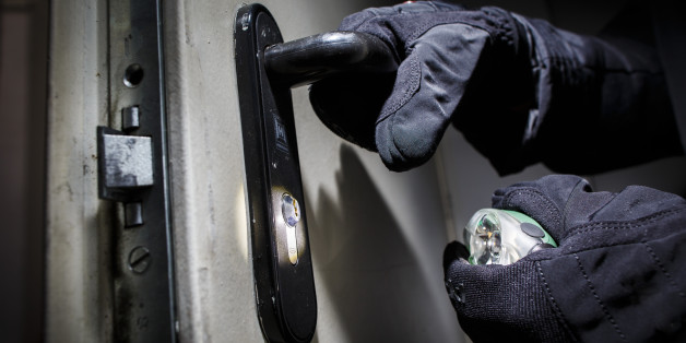 BERLIN, GERMANY - JUNE 27: Posed scene of a man opening a door with gloves and flashlight on June 27, 2014, in Berlin, Germany. The photo symbolizes the increasing risk of burglary in Germany. (Photo by Thomas Trutschel/Photothek via Getty Images)