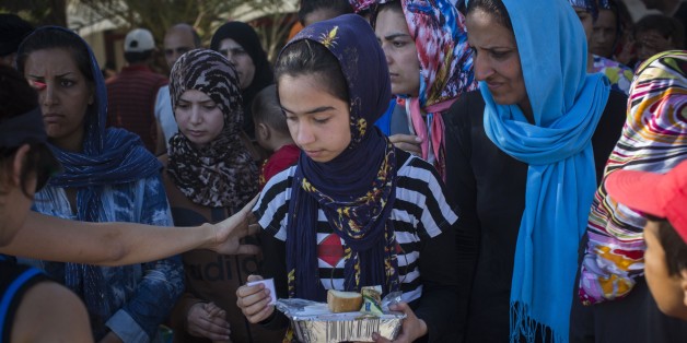 In this photo taken on Sunday, July 19, 2015 Syrian and Afghan refugees wait in line to get a meal at an abandoned hotel on the Greek island of Kos. European Union interior ministers on Monday July 20, 2015 have fallen well short of finding takers for the relocation of 40,000 refugees who have made perilous boat trips across the Mediterranean into Italy and Greece. Earlier this month, the UN said some 137,000 people had arrived in Greece, Italy, Spain and Malta alone, with many more coming by land across the Balkans. (AP Photo/Santi Palacios)