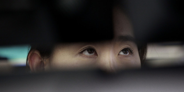 A currency trader watches monitors at the foreign exchange dealing room of the Korea Exchange Bank headquarters in Seoul, South Korea, Friday, July 11, 2014. Asian stock markets were muted Friday, following the lead of Wall Street traders spooked by worries about the soundness of a bank in Portugal that raised the specter of more financial turmoil in Europe. South Korea's benchmark Kospi dropped 0.70 percent at 1,988.74.( AP Photo/Ahn Young-joon).