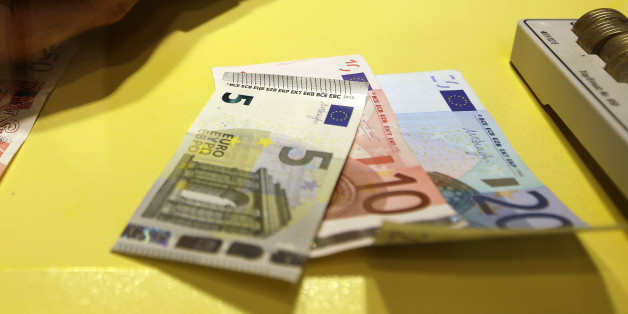 An employee counts British pounds and Euro notes at a currency exchange office in downtown Rome, Tuesday, Oct. 28, 2014. Economists have plenty of quibbles, but many agree that the Federal Reserve accomplished the bulk of its goals with its bond-buying program, known as quantitative easing, or QE. The dollar has actually held up against most major currencies, as the euro and Japanese yen have slumped. (AP Photo/Gregorio Borgia)