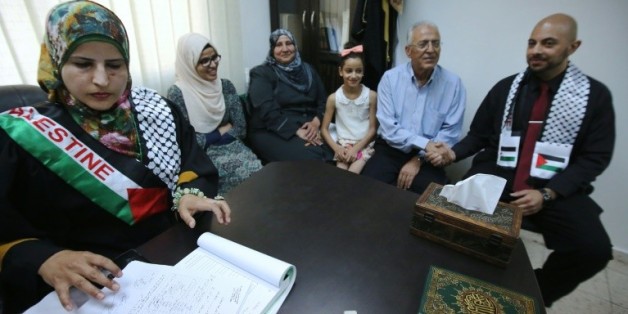 Tahrir Hamad (g), première juge à célébrer des mariages scelle une union entre Thaer (d) et Rawan (2e g) selon la loi islamique à Ramallah, le 6 août 2015
