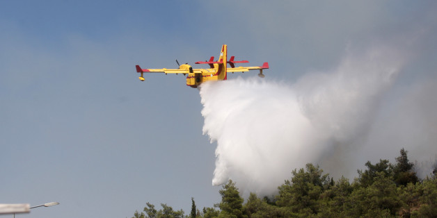 A Canadair drops water on a forest fire at the Thessaloniki Seih Sou park, which overlooks the city of Thessaloniki, on July 14, 2012. The risk of new fires was considered high, after several days of hot temperatures accross most of Greece. AFP PHOTO /SAKIS MITROLIDIS (Photo credit should read SAKIS MITROLIDIS/AFP/GettyImages)