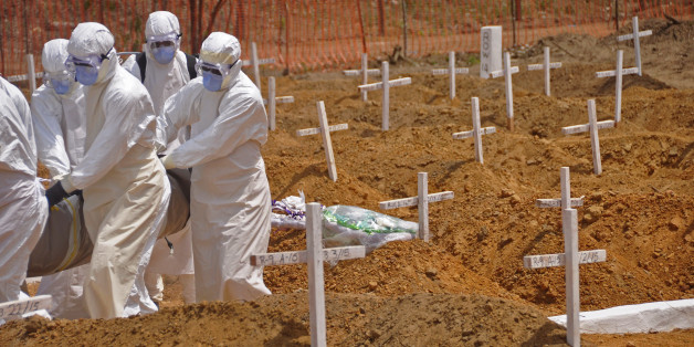 Health workers carry the body, of a person that they suspected died from the Ebola virus at a new graveyard on the outskirts of Monrovia, Liberia, Wednesday, March 11, 2015. Liberians held a church service Wednesday for families who lost members to Ebola to mark the countryâs 99th celebration National Decoration Day, a holiday normally set aside for people to clean up and re-decorate the graves of their lost relatives. (AP Photo/Abbas Dulleh)