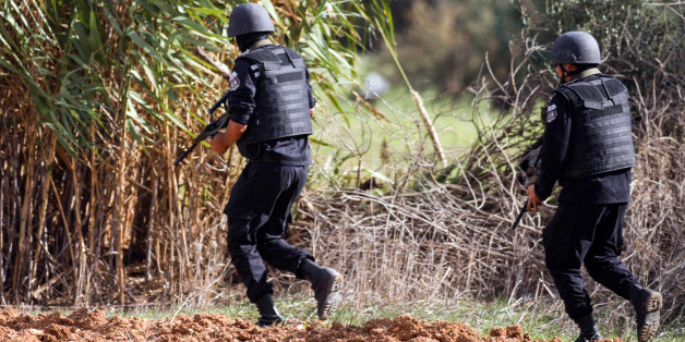 Members of the Tunisian National Guard take positions as they secure the scene of a shooting in the Oued Ellil suburb of Tunis, Tunisia, Thursday, Oct. 23, 2014. A Tunisia official says a security officer has been killed in a shootout that began when a suspect's home was surrounded near the capital. Interior Ministry spokesman Mohammed Ali Aroui says the exchange of fire Thursday came after a pair of counterterrorism operations in the south that left one bystander dead. (AP Photo/Aimen Zine)