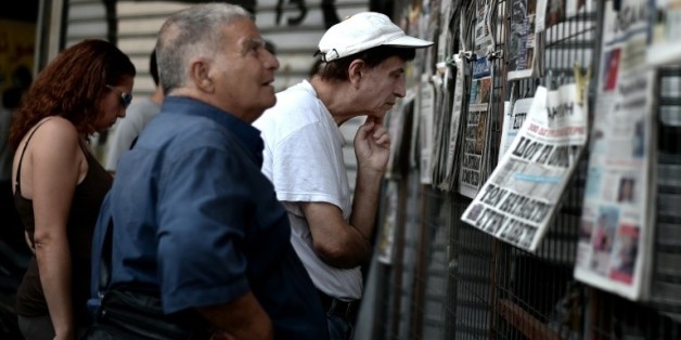 Des Grecs lisent les journaux du jour dans le centre d'Athènes, le 31 juillet 2015