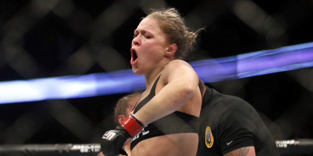 Ronda Rousey celebrates defeating Liz Carmouche after their UFC 157 women's bantamweight championship mixed martial arts match in Anaheim, Calif., Saturday, Feb. 23, 2013. Rousey won the first womenâs bout in UFC history, forcing Carmouche to tap out in the first round. (AP Photo/Jae C. Hong)