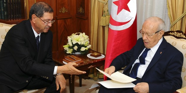 New Tunisian Prime Minister Habib Essid, left, gives Tunisian President Beji Caid Essebsi the list of the cabinet members, Friday, Jan.23, 2015 in Tunis. A month after the last election ending its democratic transition, Tunisia announces the makeup of the new coalition government tasked with seeing the country out of its current economic crisis. (AP Photo/Hassene Dridi)