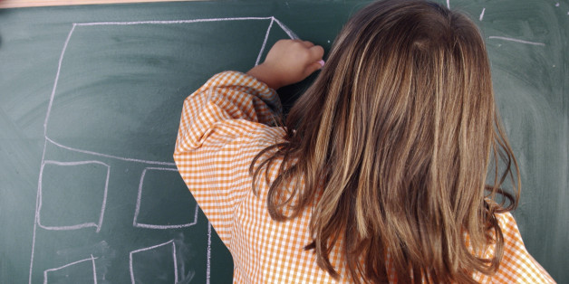 A left-handed girl drawing a house on a blackboard.Elementary and Primary School: Education
