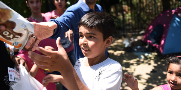 Afghan refugees reach out for food distributed by the "Solidarity For All" charity in the Pedion tou Areos park in central Athens, on Friday, July 24, 2015. Scores of migrants, mostly from Afghanistan, live in an unofficial camp in the rundown park, as Greek authorities have failed to formulate a coherent policy on how to handle a massive wave of illegal immigration. Non-governmental charities try to help, providing food and clothing. Nearly 50,000 people have illegally entered the country this year, mostly Syrian refugees who risk the sea crossing from Turkey in dangerous, overcrowded boats. From Greece, most try to continue north through the Balkans to more affluent European countries such as Germany. (AP Photo/Giannis Papanikos)