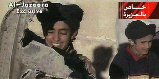 In this image made from video broadcast by the Qatari-based satellite television station Al-Jazeera Wednesday, Nov. 7, 2001, a young boy, left, identified as Hamza bin Laden holds what the Taliban says is a piece of U.S. helicopter wreckage in Ghazni, Afghanistan on Monday, Nov. 5, 2001. The Qatar based broadcaster identified the boy as one of the sons of Osama bin Laden, the prime suspect in the Sept. 11, attacks on the United States. Boy at right is unidentified. Graphic at top right reads "Ex