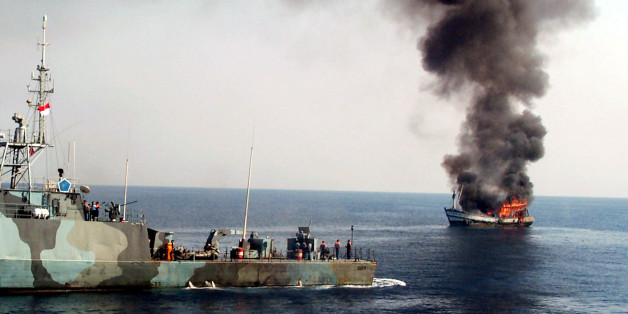 Smoke billows from M.V. Karunia Laut-1, left, as it caught on fire after being shot by an Indonesian Navy patrol boat off Surabaya, East Java, Tuesday, Nov. 11, 2003. The M.V. Karunia Laut-1 was destroyed after the Thai crew on board was arrested for illegal fish poaching in the waters north of Bawean island in eastern Indonesia on Sunday. Illegal fishing costs Indonesia about $3 billion a year. (AP Photo/Trisnadi)