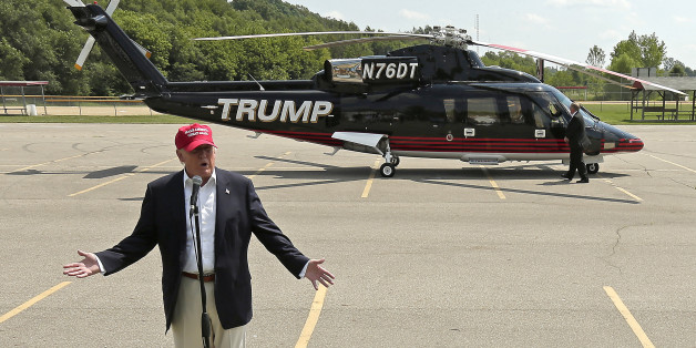 Republican presidential candidate Donald Trump talks to the media after arriving by helicopter at a nearby ballpark before Trump attended the Iowa State Fair Saturday, Aug. 15, 2015, in Des Moines. (AP Photo/Charlie Riedel)