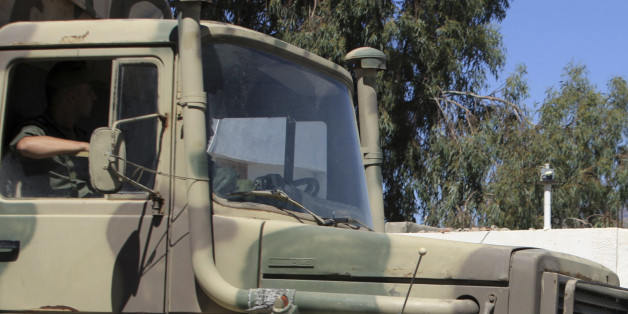 A military truck parks outside the hospital of Kasserine, near the Algerian border, Thursday, July 17, 2014. Militants in western Tunisia staged two simultaneous attacks on army posts while soldiers held a Ramadan feast, killing at least 14 soldiers, authorities said Thursday. (AP Photo/ Mouldi Kraeim)