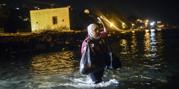 Une migrante marche vers un bateau pour embarquer de Bodrum, ville touristique sur la côte égéenne en Turquie, pour l'île de Kos en Grèce, le 18 août 2015