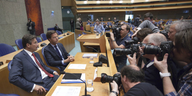 Photographers and cameramen crowd around caretaker Prime Minister Mark Rutte, second left, and deputy prime minister Maxime Verhagen, left, in parliament in The Hague, Netherlands, Tuesday April 24, 2012. Rutte appealed to a polarized Dutch Parliament on Tuesday to help him get the economy back on track rather than let the country drift in political limbo until new elections. Speaking publicly for the first time since he tendered his resignation Monday, Rutte said the nation, long considered one of Europe's most fiscally responsible, has no time to waste in tackling its economic woes. (AP Photo/Peter Dejong)