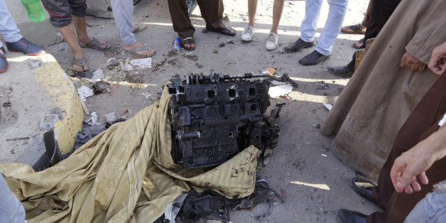 Des Egyptiens devant le moteur du véhicule utilisé dans un attentat visant le bâtiment de la sécurité nationale le jeudi 20 août 2015, dans le quartier de Shubra El Kheima au Caire