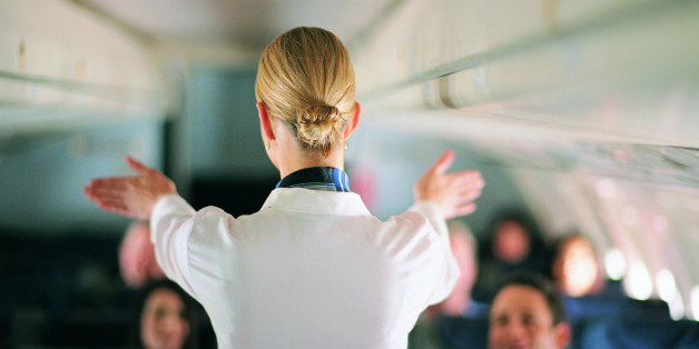 Rear View of Air Stewardess Explaining Aeroplane Safety to Passengers