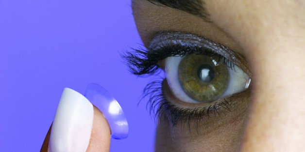 Photo, woman putting a contact lens in her eye, eye only, close-up, Color, Low res