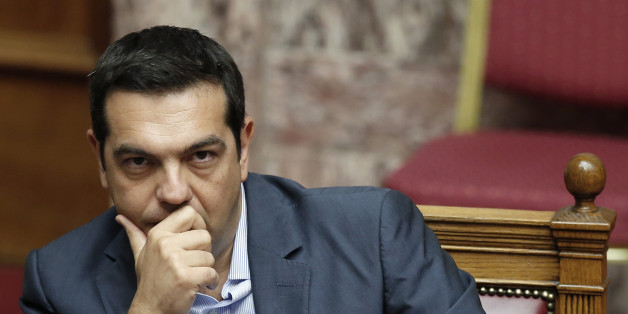 Greek Prime Minister Alexis Tsipras liestens during a parliamentary session in Athens, Friday, Aug. 14, 2015. Greek lawmakers are continuing a debate in parliament to approve a massive new bailout deal after repeated delays over procedure and dissent within the governing left-wing Syriza party caused the session to last through the night. (AP Photo/Yannis Liakos)